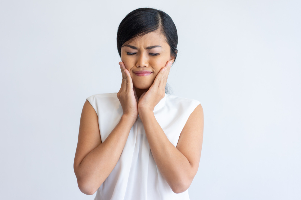 A woman in pain from Bruxism (teeth clenching and grinding)